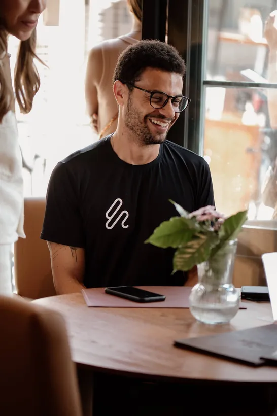 Cliente sorrindo à mesa da Casa São Lucas